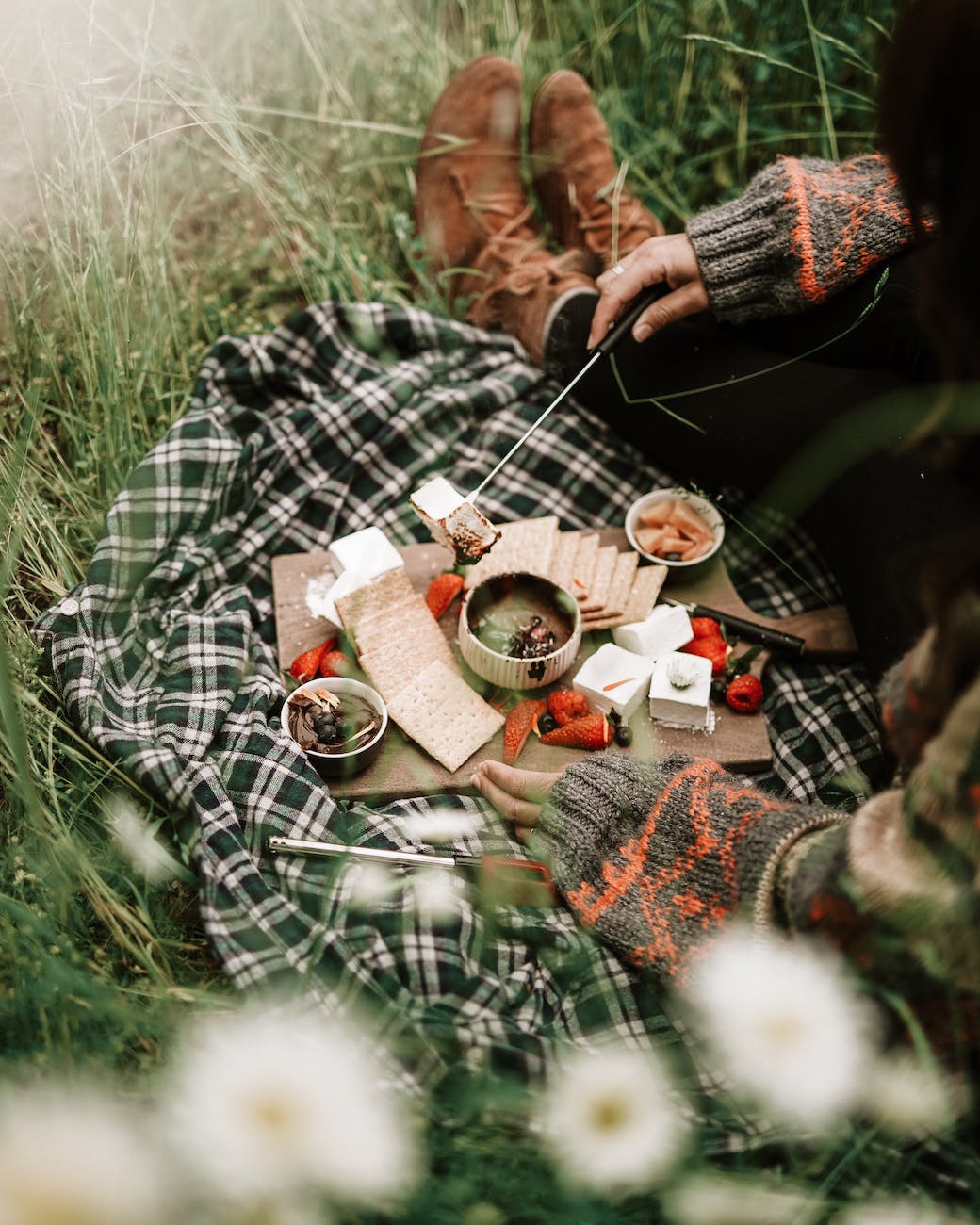 person in black and white plaid long sleeve shirt having a picnic