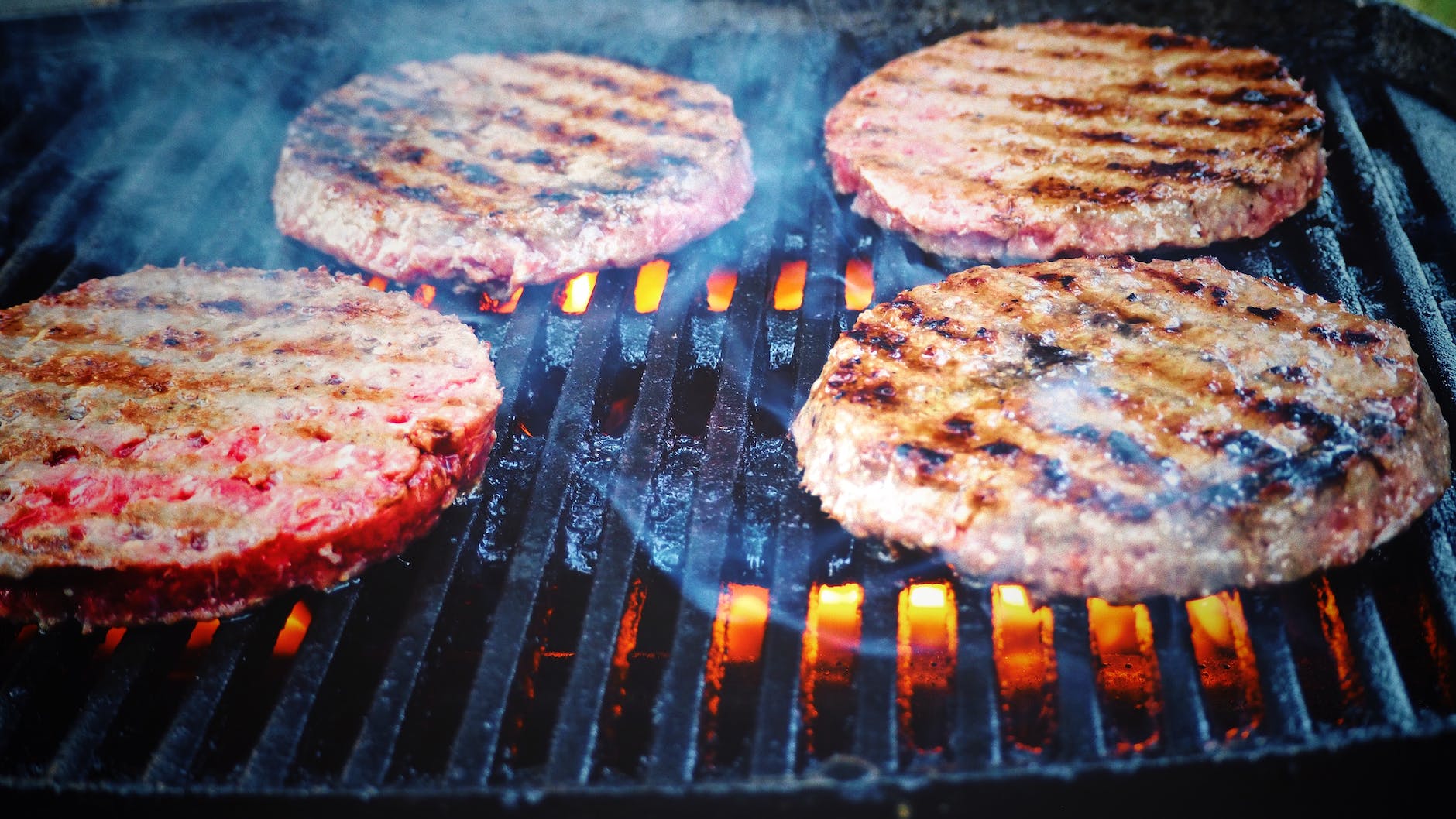 shallow focus photo of patties on grill